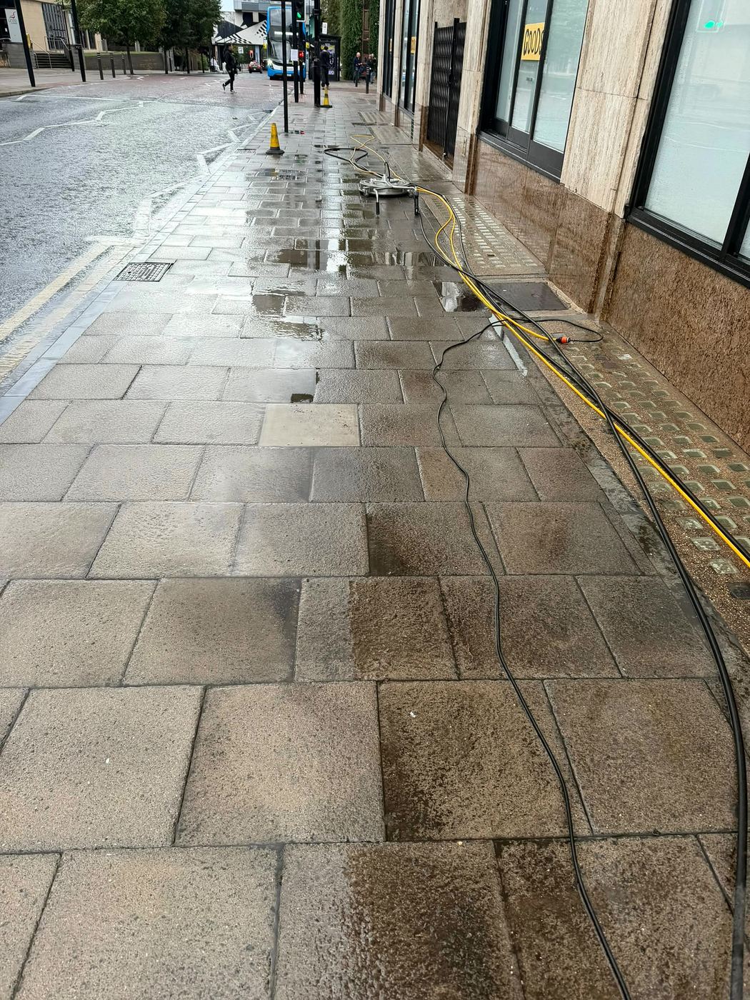 City-centre pavement outside a shopfront after jet washing